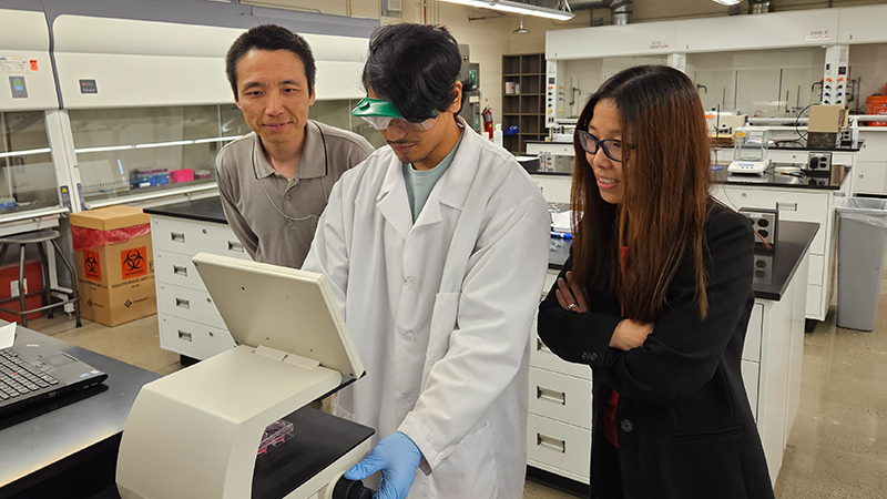 Bryan Cadavos ’24 (center) with his faculty mentors Chong Qiu, Ph.D., and Shue Wang, Ph.D.