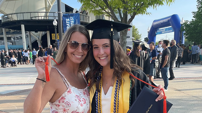 Tara Butler ’02 with her niece Olivia Dittmann ’22 at Commencement. They are holding the legacy cord Dittman received because Butler is an alum.