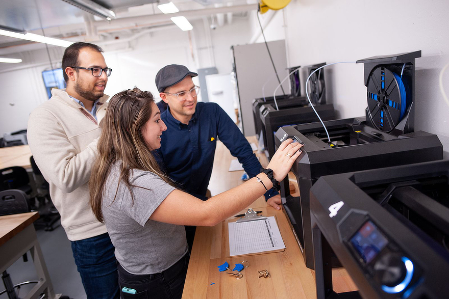 Student and teachers at 3D printer