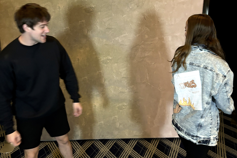 Alec Benjamin reacting to Marina Del Santo ’28, ’29 MBA's hand-painted jacket. 