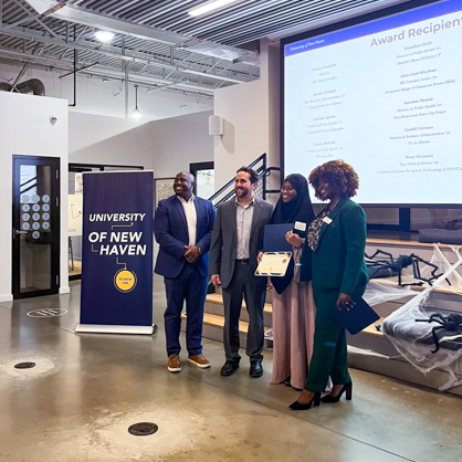 Secora Chambers ’23, ’24 MBA (second from right) receiving award from Helping Hands