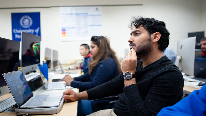 A student looking at a professor teaching.