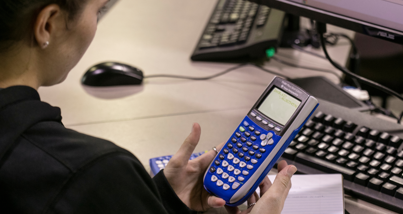Hands holding a graphing calculator