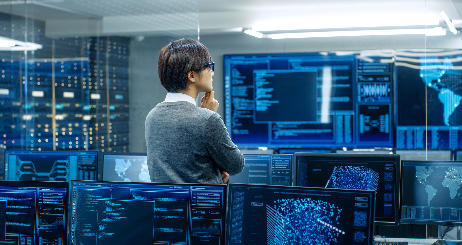 Man looking at data on computer screens