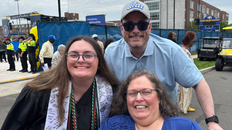 Mia Ribellino ’25, ’26 M.S. poses with family at Commencement.