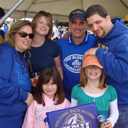 Mia Ribellino ’25, ’26 M.S. (front left) with Charger family at University of New Haven homecoming.