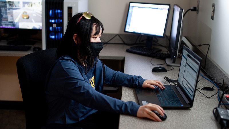 Image of cybersurity student on the computer.