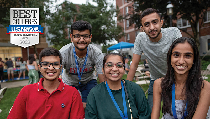 A row of students smiling and pose for the camera.