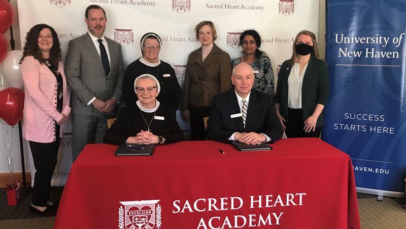 Staff from Sacred Heart Academy and University of New Haven at the signing ceremony.