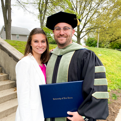 Aaron S. Marks ’24 DHSc with is wife, Nicole. She's wearing white and he's in his cap and gown, holding his diploma.