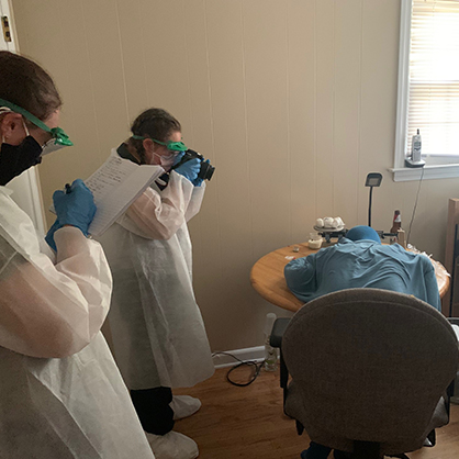 Students photograph one of the bedrooms in the University’s crime scene house.