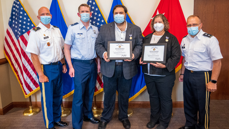 Liberty Page and Ibrahim Baggili pose with their Civilian Medal of Merit awards alongside service members.