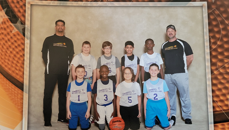 Philip Howard (left) with his son’s youth basketball team in the Stamford Peace basketball league a few years ago. 