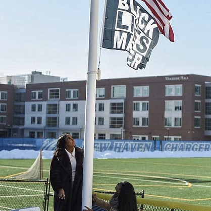 Saniyah J. Brinney raising Black Lives Matter flag
