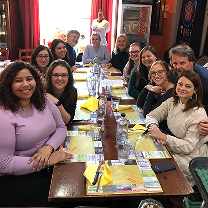 Valentina Seffer, Ph.D. (right), has lunch with students and faculty before the pandemic.