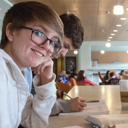 A student smiling at the camera in Westside Hall.